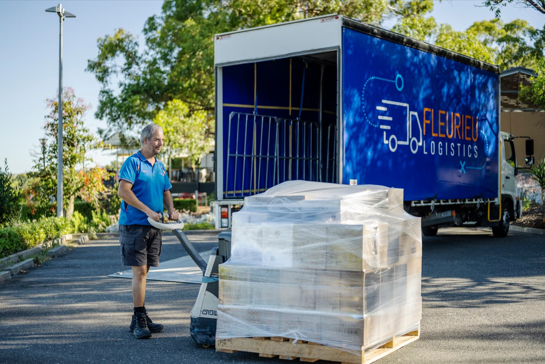 A Fleurieu Logistics team member loading a pallet beside the truck